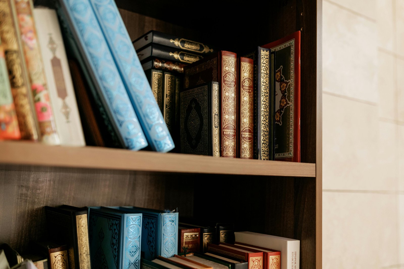 Neatly arranged Qurans and Islamic books on a wooden shelf in the Iqra classroom